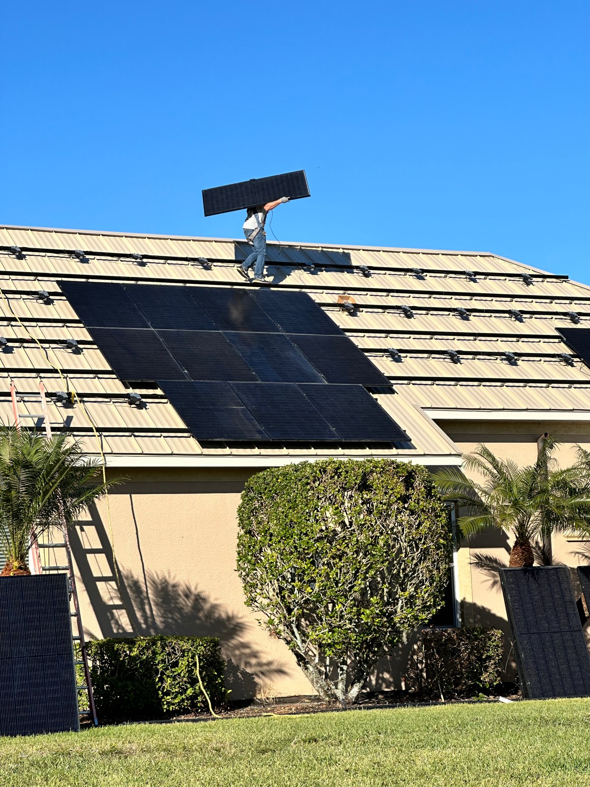 Solar panel handling during a GreenReady project on a metal roof