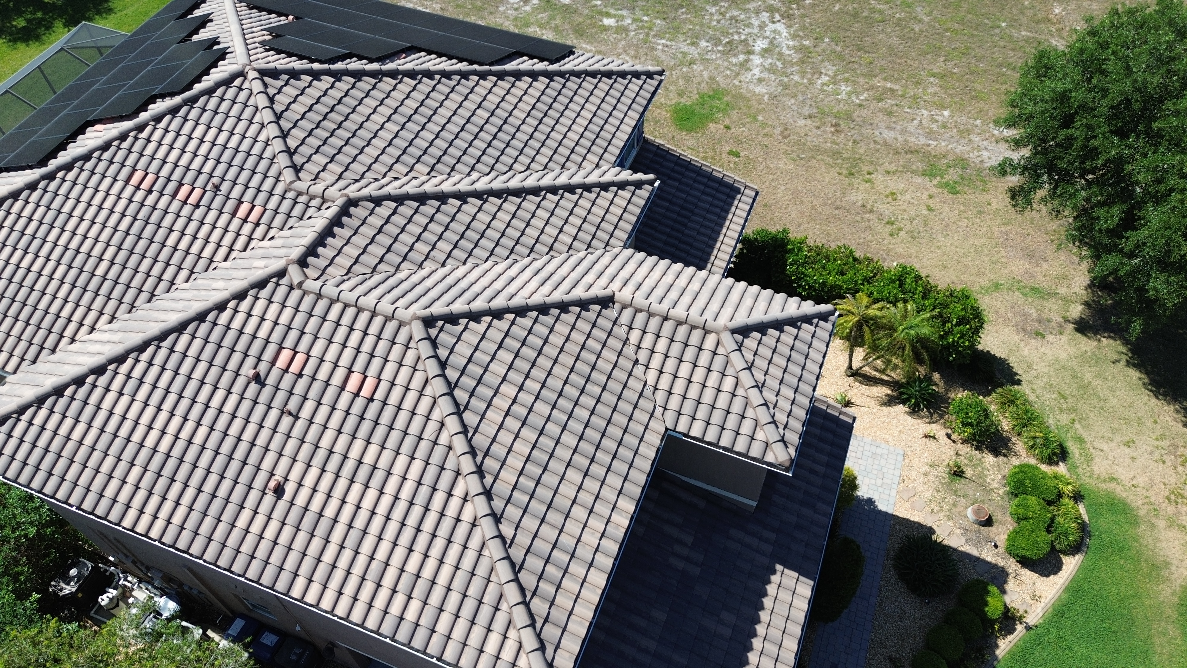 Tile roof with existing solar panels, from GreenReady’s published Bradenton roofing project photography